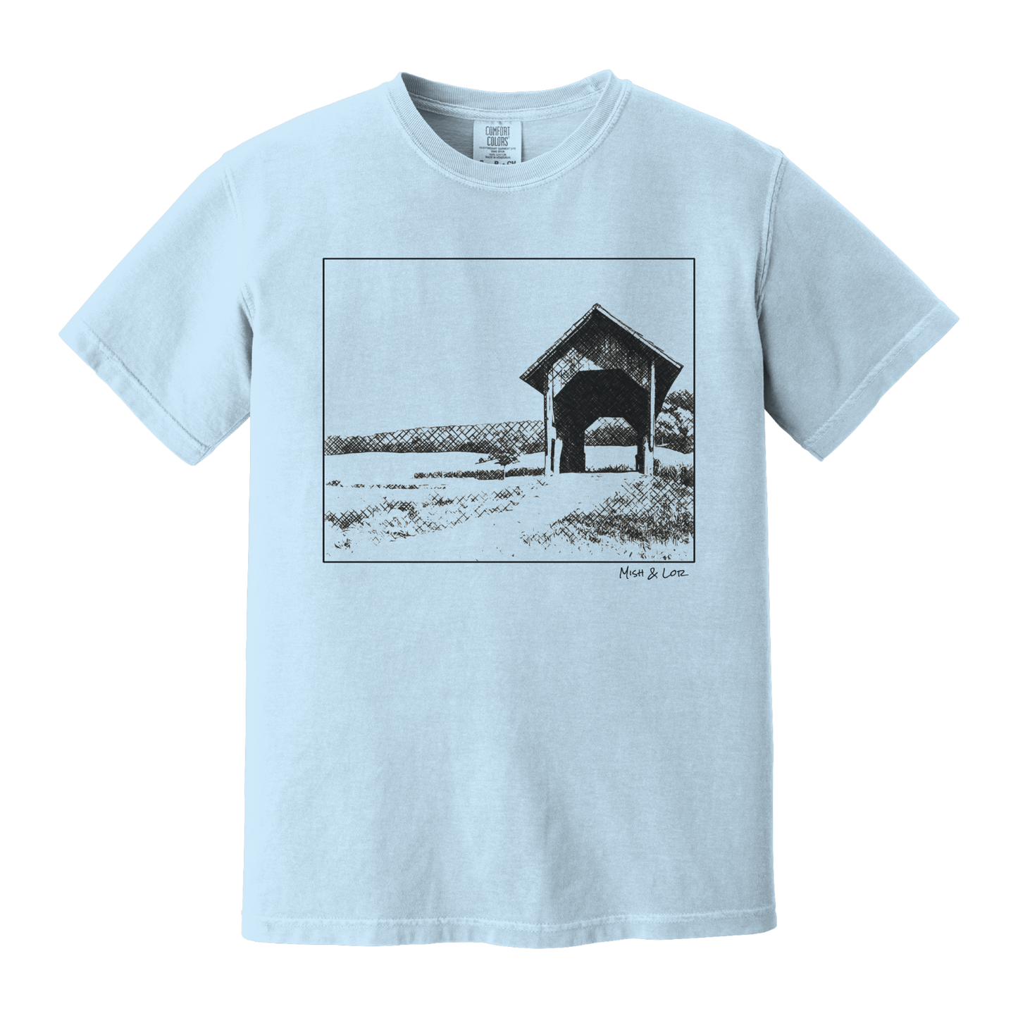 Front view of the Covered Bridge cotton t‑shirt in Chambray (baby blue), with a storybook scene of a rustic covered bridge arching over a quiet Vermont dirt road.