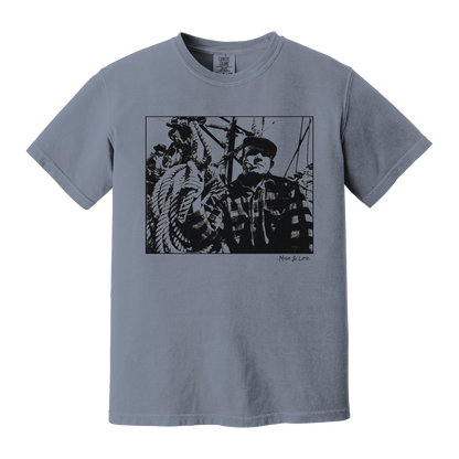 Front view of the Fisherman Cotton T-Shirt in Blue Jean (dusty blue), featuring a vintage portrait of a fisherman in flannel, gripping ropes on a boat with a cigar in his mouth.